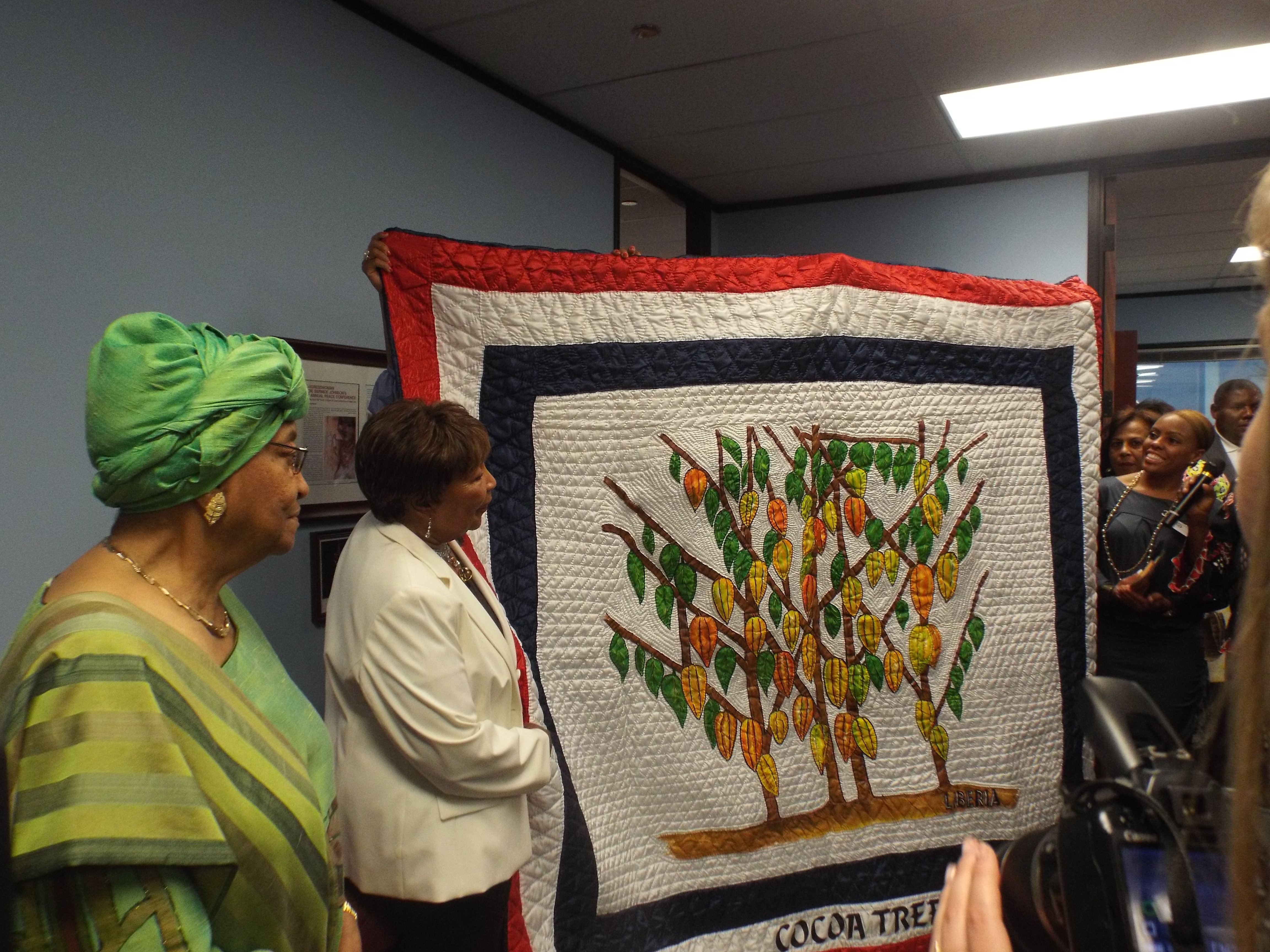 /Congresswoman Johnson admires a hand-woven quilt gift from President Sirleaf 